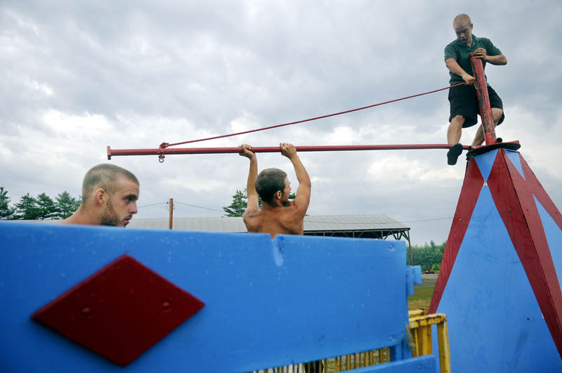 GOING UP: Carnival workers with Kavanaugh Amusements assemble a ride Tuesday at the Pittston Fair ahead of an approaching thunderstorm. The annual agricultural exhibit commences Thursday and runs through Sunday