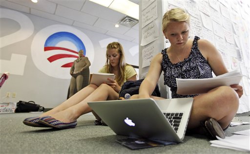 In this photo taken June 28, 2012, President Barack Obama 2012 volunteers Liesa Collins, left, and Mindy Bertram, enter data as they work at a call center for the campaign in Richmond, Va. Call them passionate, idealistic, earnest, even a tad naive: The volunteers helping to power the Obama and Romney campaigns are outliers at a time when polls show record low public satisfaction with government and a growing belief that Washington isn�t on their side. While motivated by opposing goals, the Obama and Romney volunteers share at least one key trait: an abiding faith in the political process and a belief that it still matters who occupies the White House. (AP Photo/Steve Helber)