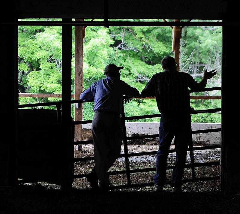 Agriculture Commissioner Walt Whitcomb, left, chats with dairy farmer Berndt Graf after a Kennebec Land Trust event on Saturday morning in Fayette.