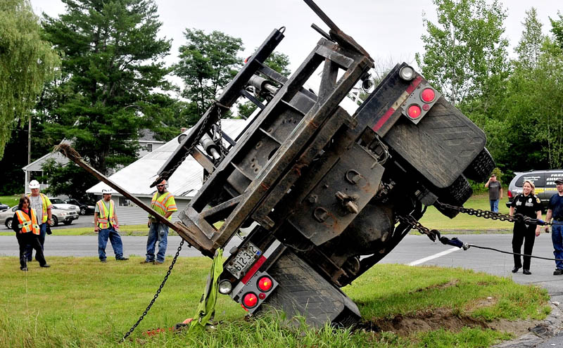 Fairfield police officer Shanna Blodgett, right, and Maine Department of Transportation employees watch as a tow truck pulls a truck upright after it collided with another vehicle at the intersection of U.S. Route 201 and 23 on Thursday, injuring two occupants. The intersection has been the site of numerous serious and fatal accidents.