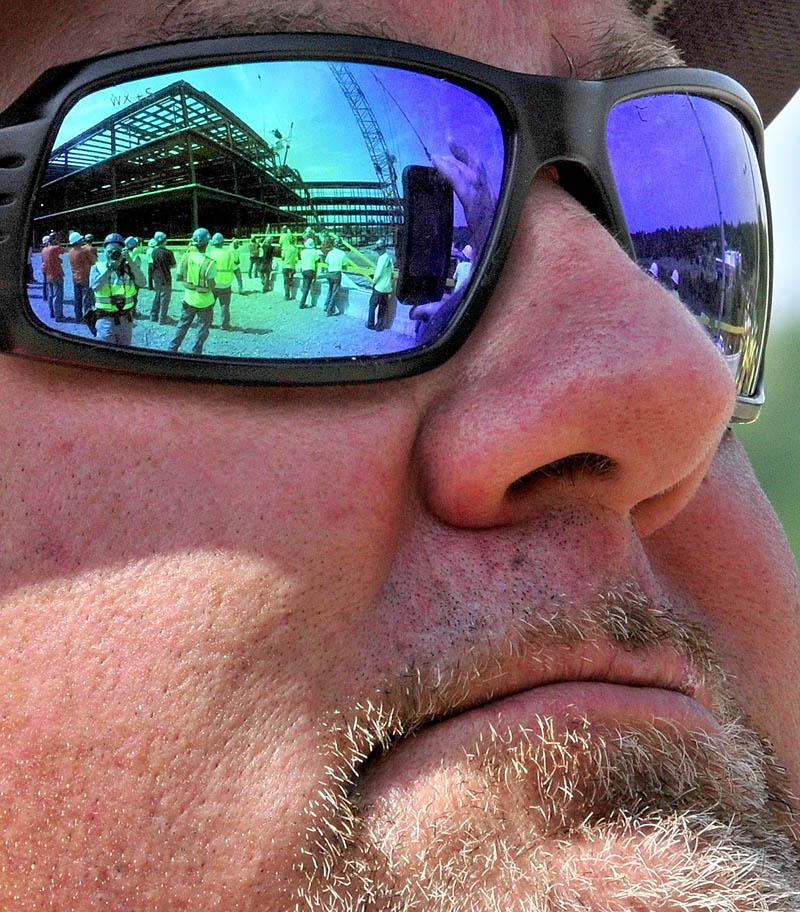 Staff photo by Joe Phelan Chip Pocock, of Buckner Steel Erection, watches as the final beam is lifted into place during the topping out ceremony on Monday morning at the construction site of Maine General Medical Center's new regional hospital in north Augusta. The beam was signed by many people and the tree was dug up from and will be returned to the site.