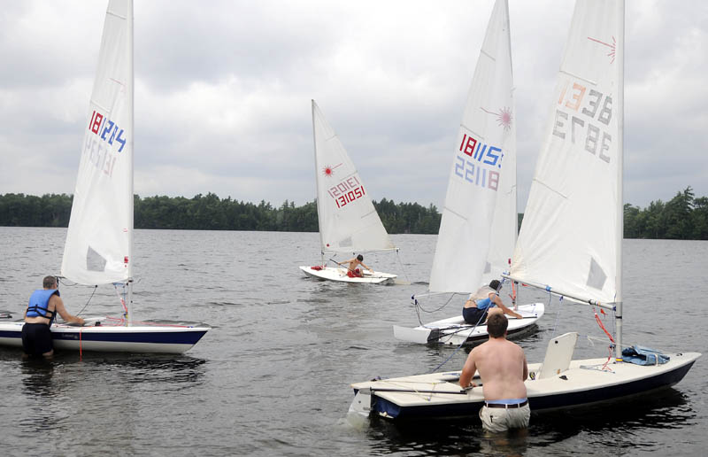 REGATTA: Members of the Cobbosseecontee Yacht Club launch sailboats Sunday onto the lake from the Club in Manchester. The sailors were taking part in the fifth annual Lighthouse Regatta to celebrate the 104th anniversary of the Lighthouse on Lake Cobbosseecontee. Over a dozen one-man crafts hoisted sails and raced across the lake Sunday afternoon before returning to the Club for a cookout.