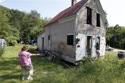 Janet Lumbra looks over the remains of her home in East Granville, Vt.