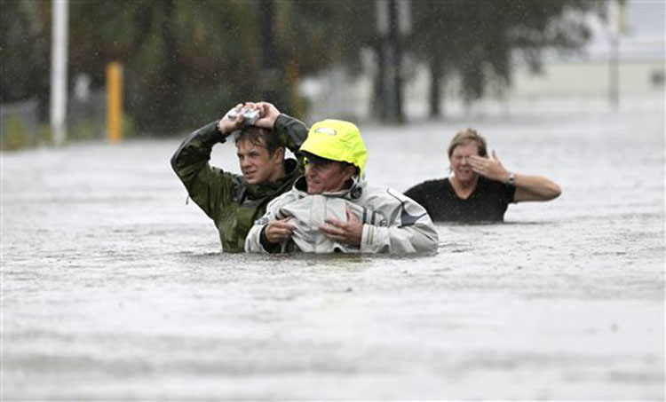 Chuck Cropp, center, his son Piers, left, and wife Liz, right, wade through floodwaters from Hurricane Isaac Wednesday, Aug. 29, 2012, in New Orleans. As Isaac made landfall, it was expected to dump as much as 20 inches of rain in several parts of Louisiana. (AP Photo/David J. Phillip)