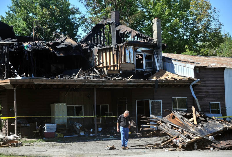 Fire Chief Tom Keene, of the Skowhegan Fire Department inspects debris outside a home on Canaan Road in Skowhegan that was destroyed by fire the night before.