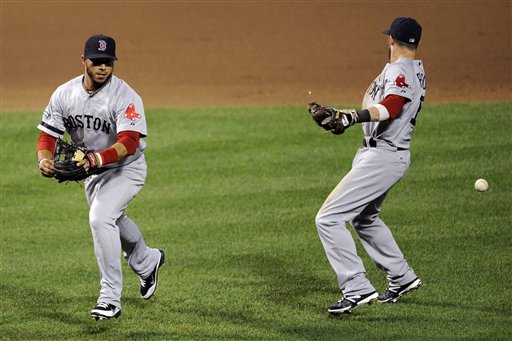 Boston Red Sox second baseman Dustin Pedroia, right, and shortstop Mike Aviles, left, cannot make a play on a ball that went for a single by Baltimore Orioles' Matt Wieters, during the sixth inning of a baseball game, Tuesday, Aug. 14, 2012, in Baltimore. The Orioles won 7-1. (AP Photo/Nick Wass)