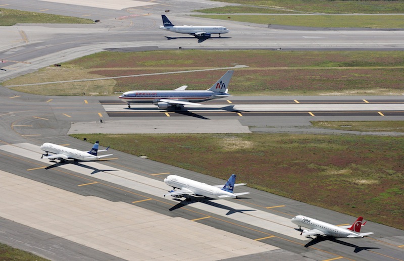 In this Sept. 8, 2008 file photo, planes taxi on runways at John F. Kennedy International Airport in New York. A man on a personal watercraft who became stranded in a bay easily breached Kennedy International Airport's security system, on Sunday, Aug. 12, 2012, by walking undetected across two runways and into a terminal. Daniel Casillo, 31, swam to a Jamaica Bay shore and then walked past motion sensors and closed-circuit cameras of the airport's state-of-the-art Perimeter Intrusion Detection System. The $100 million system, manufactured by defense contractor Raytheon Co., is meant to safeguard against terrorists. (AP Photo/Mark Lennihan, File) aerial photo airplanes jets port authority air traffic