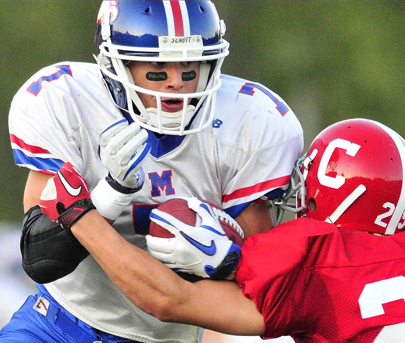COMING THROUGH: Messalonskee’s Sam Dexter is hit by Cony’s Tayler Carrier during the opening game of the season Friday night at Alumni Field in Augusta.