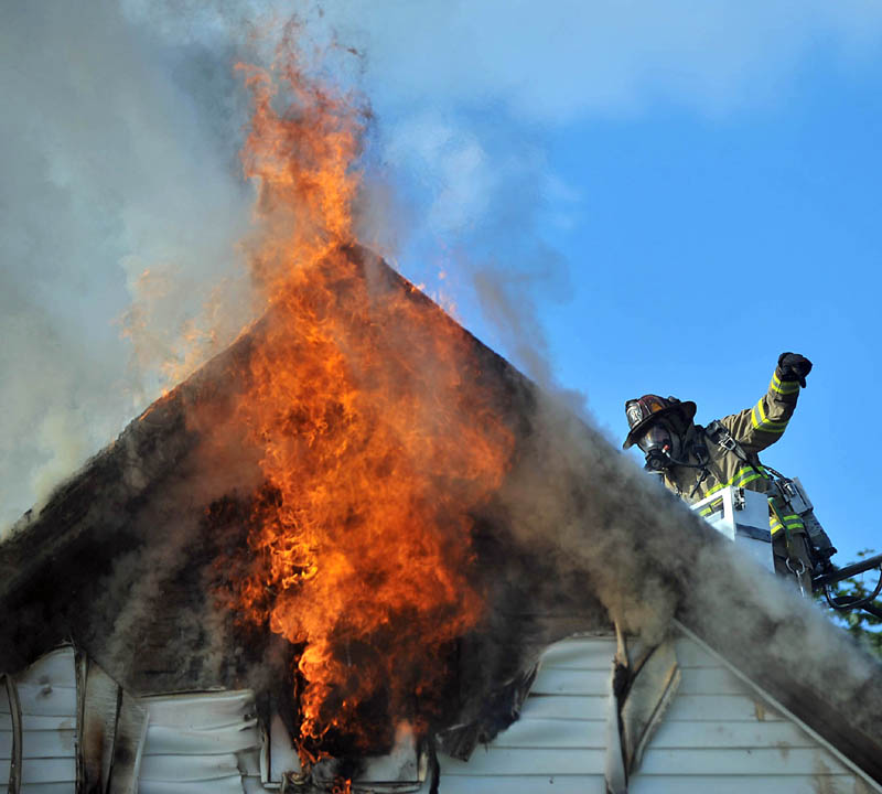 Firefighters battle a blaze on Spruce Street in Waterville Wednesday.