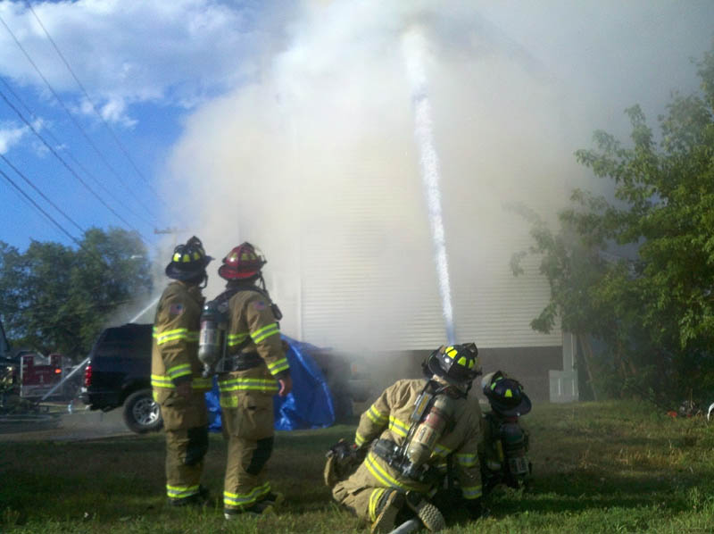 More than 20 firefighters are battling a two-apartment house fire at 38 Spruce Street in Waterville. The fire has engulfed the attic and partially collapsed the roof.