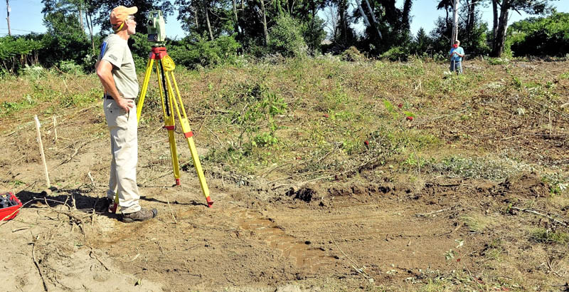 Surveyors Bob Knowlton, left, and Frank Siviski of Broken Stone Survey company, work in the cleared area off Colby Circle in Waterville on Monday where the new police station will be built.