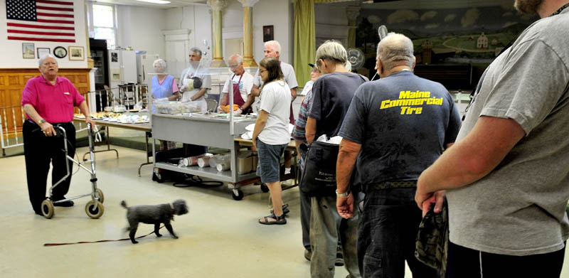 Dick Willette leads a prayer for patrons during lunch at the Sacred Heart Soup Kitchen in Waterville on Monday. Willette said the organization is in danger of closing soon unless additional funding is found.