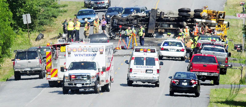 Police officers and firefighters work at the scene of a serious motor vehicle accident this afternoon on U.S. Route 202 near the East Winthrop Post Office.