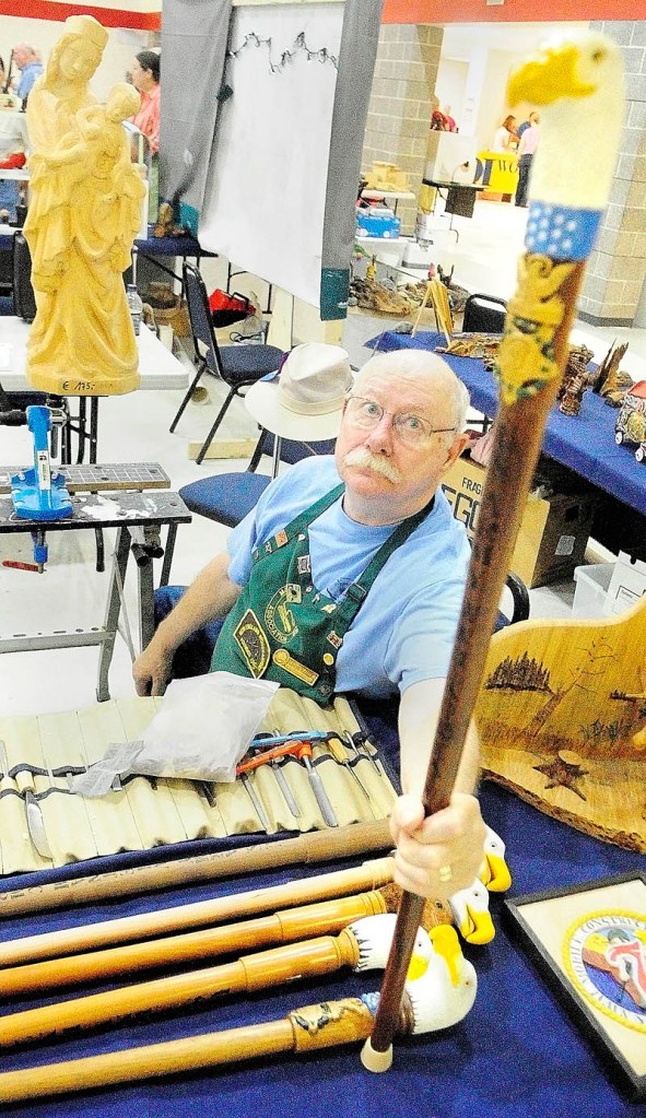 Chuck Friis, president of the Poland Springs chapter of the Maine Wood Carvers Association, talks about the eagle cane project at the Downeast Woodcarving & Wildlife Art Show at the Augusta Armory.