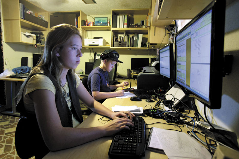 In this photo taken Tuesday, Dec. 13, 2011, Celestial McBride, left, 14, and her brother Sevan, 12, work on an online classes from the Florida Virtual School from their home in Mims, Fla. (AP Photo/John Raoux)