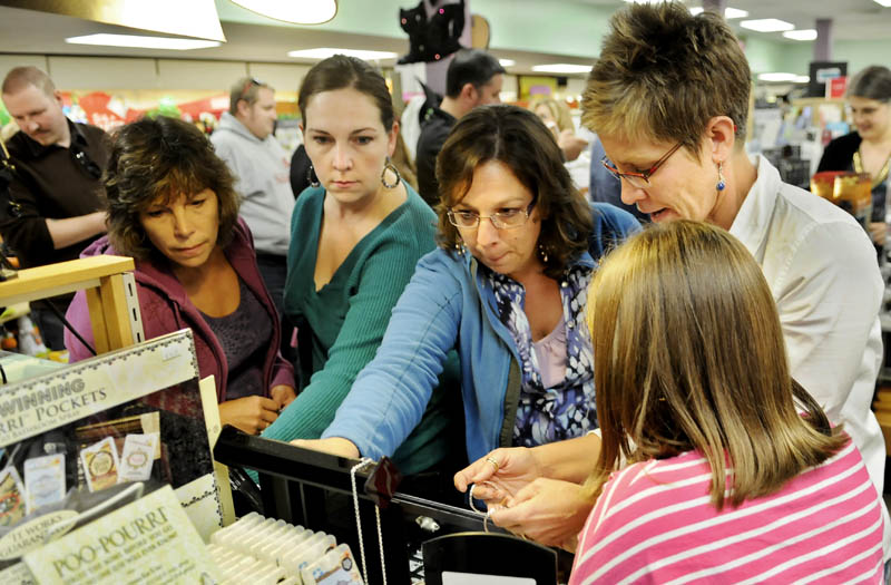 Staff photo by Andy Molloy THE MOB: Members of the cash mob that descended upon Water Street in Augusta on Thursday shop at Stacy's Hallmark. Several people descended on the business to spend $20.00 each before gathering at a downtown bar.