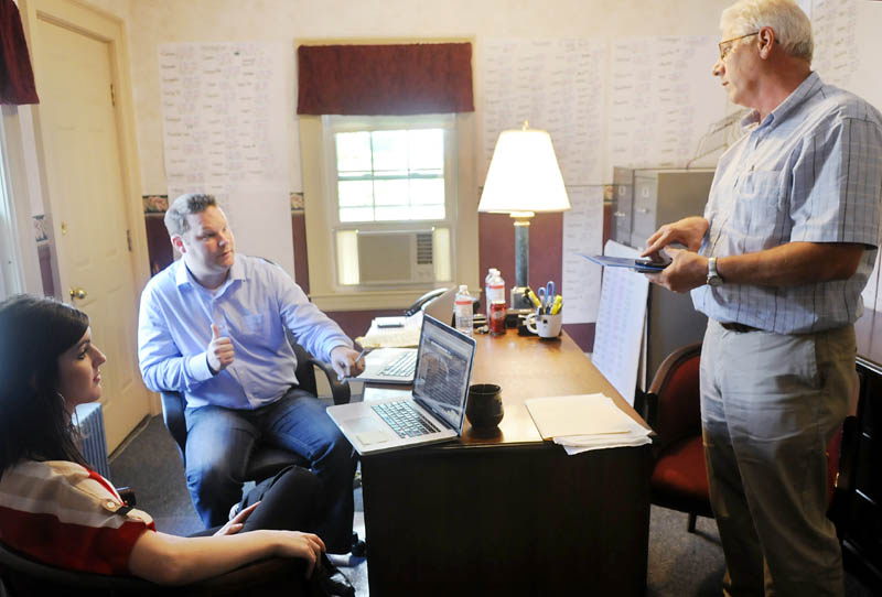 Bob Emrich, right, confers with Megan and Matt Huston on Tuesday at the Maine Christian Civic League in Augusta. The League has retained the Hustons to run the campaign against same-sex marriage.
