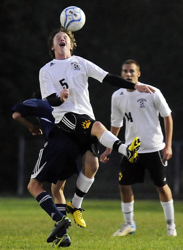 SKY HIGH: Maranacook Community High School’s Chris Beckwith heads the ball on the back of Stephen Goodridge, of Oceanside High School, as Maranacook’s Zach Elwell, right, looks on during the Black Bears’ 3-2 win Tuesday in Readfield.