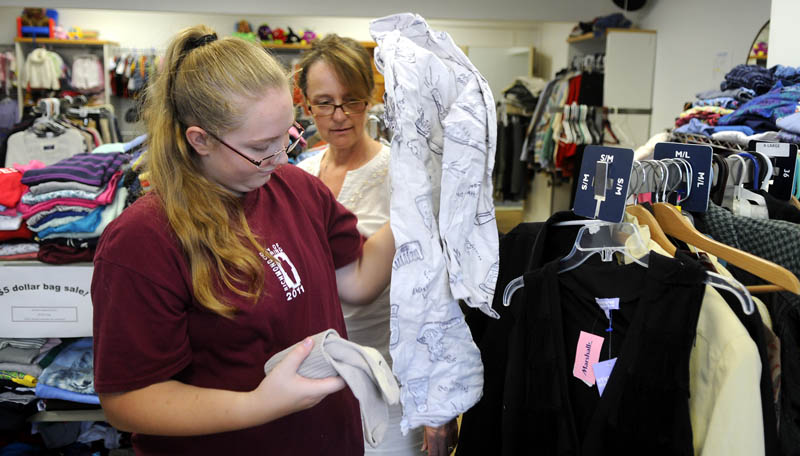 THRIFTY: Katrena Oakes, left, and Pastor Gayle Holden sort clothes Wednesday at the House of Richmond Thrift Store. Oakes, Holden and fellow volunteer Kelli Terry sorted, folded and hung items for sale at the new venture located in Richmond's down town.