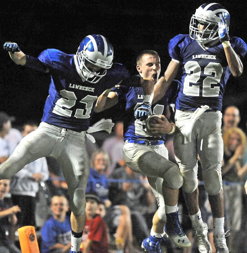 BULLDOGS CELEBRATE: Lawrence High School’s Josh Doolan, center, celebrates after an apparent touchdown with teammates Aaron LeFrance, left, and Xavier Lewis in the second quarter against Bangor High School on Friday at Lawrence High School in Fairfield. Doolan’s helmet came off during the play, so the ball was placed on the 10-yard line. Lawrence won 42-12.
