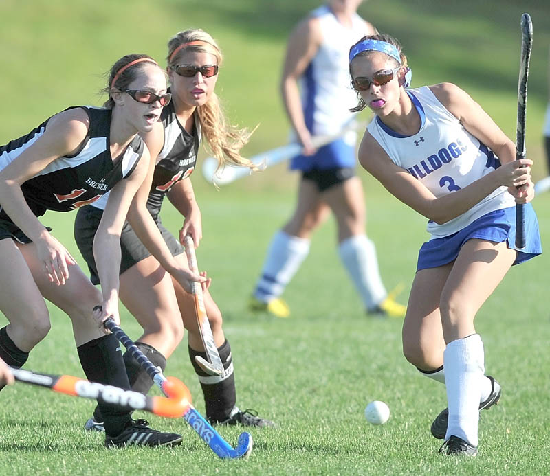 Staff photo by Michael G. Seamans Lawrence High School's Taylor Watson, 3, passes the ball as Brewer High School defenders Lindsay Houp, 14, left, and Rachel Triplett, 12, defend in the first half in Fairfield Tuesday.