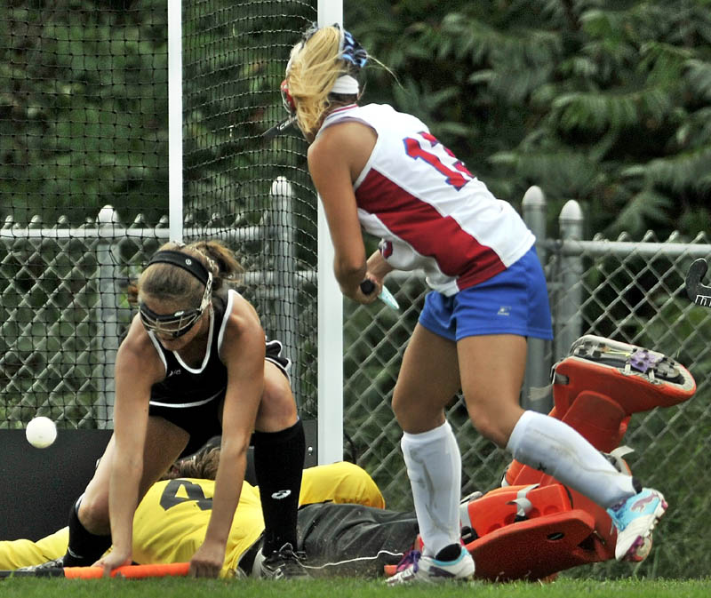 TEAM EFFORT: Skowhegan’s Sarah Finnemore, left, saves a shot by Messalonskee’s Emily York as Skowhegan goalie Anne-Marie Provencal, back, dives for the save in the second half Saturday at Messalonskee High School in Oakland.