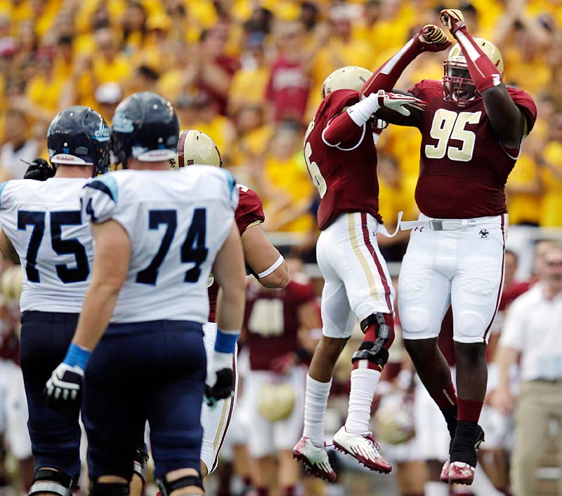 Boston College defensive lineman Dominic Appiah, 95, celebrates with C.J. Jones, 6, after the Maine fumbled on a punt near the Boston College end zone in the first half Saturday at Alumni Stadium in Chestnut Hill, Mass. At left are Maine's Joe Hook, 75, and Josh Spearin, 74.