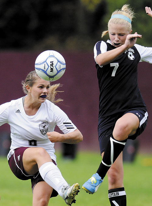 OVER THE TOP: Monmouth’s Sabrine Beck, left, kicks the ball away from St. Dominic’s Kayla McLellan during a game Monday in Monmouth.
