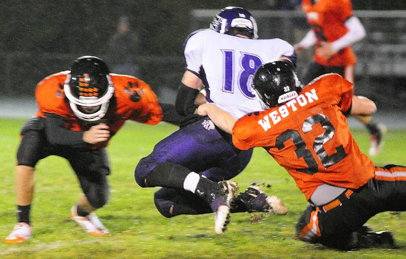 BRINGING HIM DOWN: Gardiner defenders Tyler Jamison, left, and Brad Weston, right, combine to take down Hampden’s Matt Martin on Friday at Hoch Field in Gardiner.