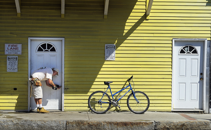 A man works on a door on the back of Harbour's Edge on Custom House Wharf on Friday.