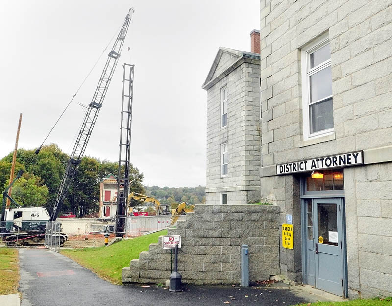 A jury trial was moved from the Kennebec County Superior Court House, right, because of the noise from the pile driving operations, left, that are part of the construction for a new court house.