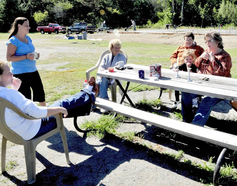 WORK IN PROGRESS: New Hope Women's Shelter Director Rebecca Philpot, right, speaks with guests outside the Solon facility on Wdnesday as work is being done on a new shelter in back. Guests from left are Jennifer Wright, Janice Giggey, Linda Drummond, Lynne Olsen and Wright's daughter Aubrey.