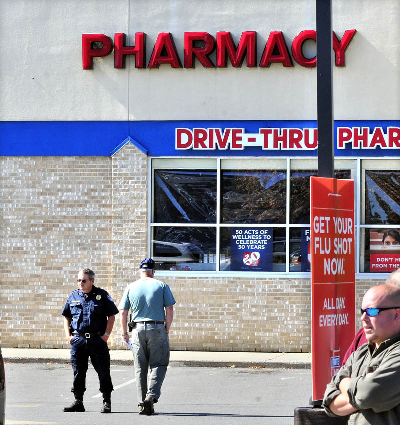 SECOND TIME: Pittsfield Police Chief Steven Emery, left, and officer Tim Roussin outside the RiteAid store in Pittsfield on Tuesday shortly after a male suspect handed a note to an employee demanding drugs. The suspect left the store without drugs and did not reveal the gun that he claimed he had.