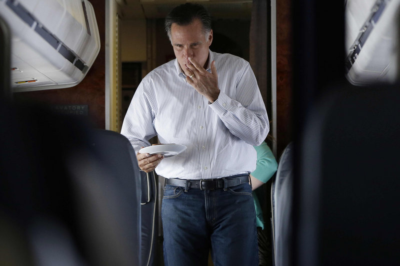 Republican presidential candidate and former Massachusetts Gov. Mitt Romney licks his fingers as he walks back to his seat after making himself a peanut butter and honey sandwich on his campaign plane en route to Las Vegas on Friday.