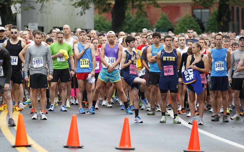 The runners for the marathon and half marathon pause just before the start of the race Sunday in Portland for the playing of the national anthem.