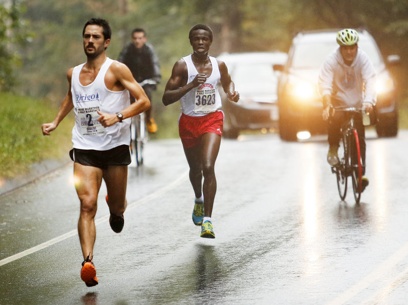 Robert Gomez of Saco, front, and Moninda Marube of Auburn approach the 10-mile mark during Maine Marathon on Sunday along Route 88 in Cumberland. While Gomez broke Vassallo’s previous record, he didn’t beat Vassallo.