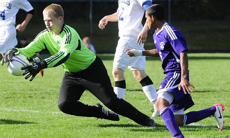 STOP THAT BALL: Erskine Academy keeper Jared Gartley, left, makes a save in front of Waterville’s Denilo Guthro during a game Thursday at Erskine Academy in South China.
