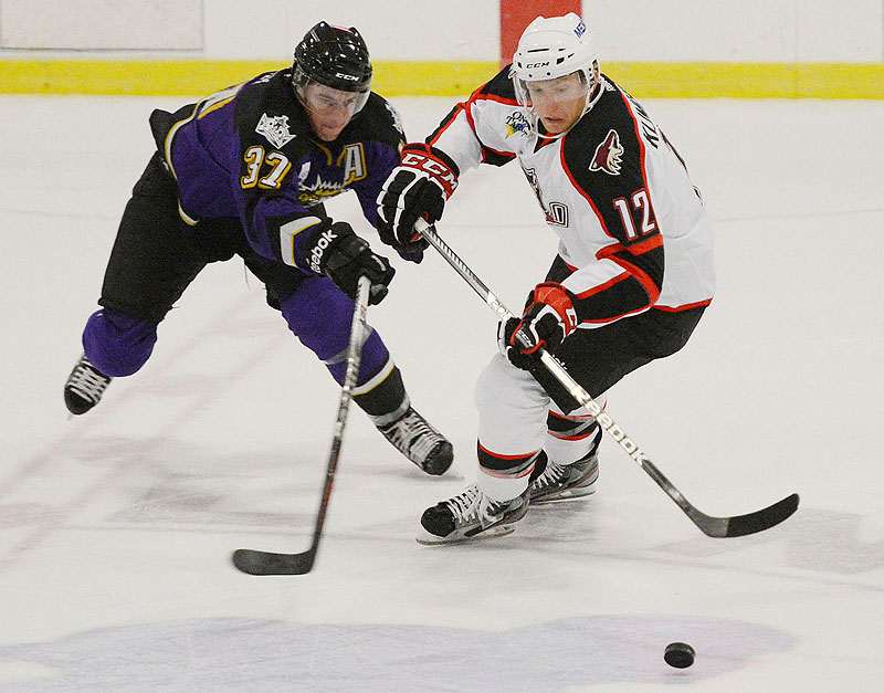 Thomas Hickey of Manchester battles for the puck with Portland's Rob Klinkhammer in an exhibition game Sunday at the Portland Ice Arena. The Monarchs won 4-3 in OT.