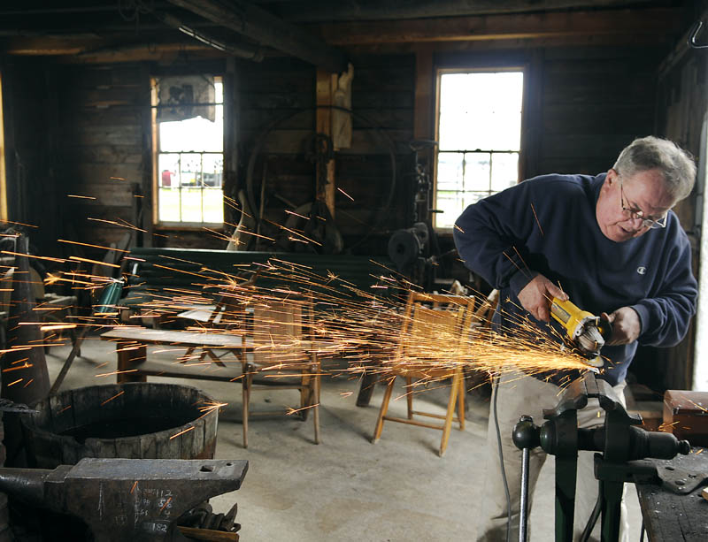 MANDREL MAKER: Bill Forbes brushes a mandrel Tuesday he created in the foundry of the blacksmith shop located on the grounds of the Windsor Historical Society. Forbes said he hopes to assemble the handle and blade of the axe with the new mandrel this week.