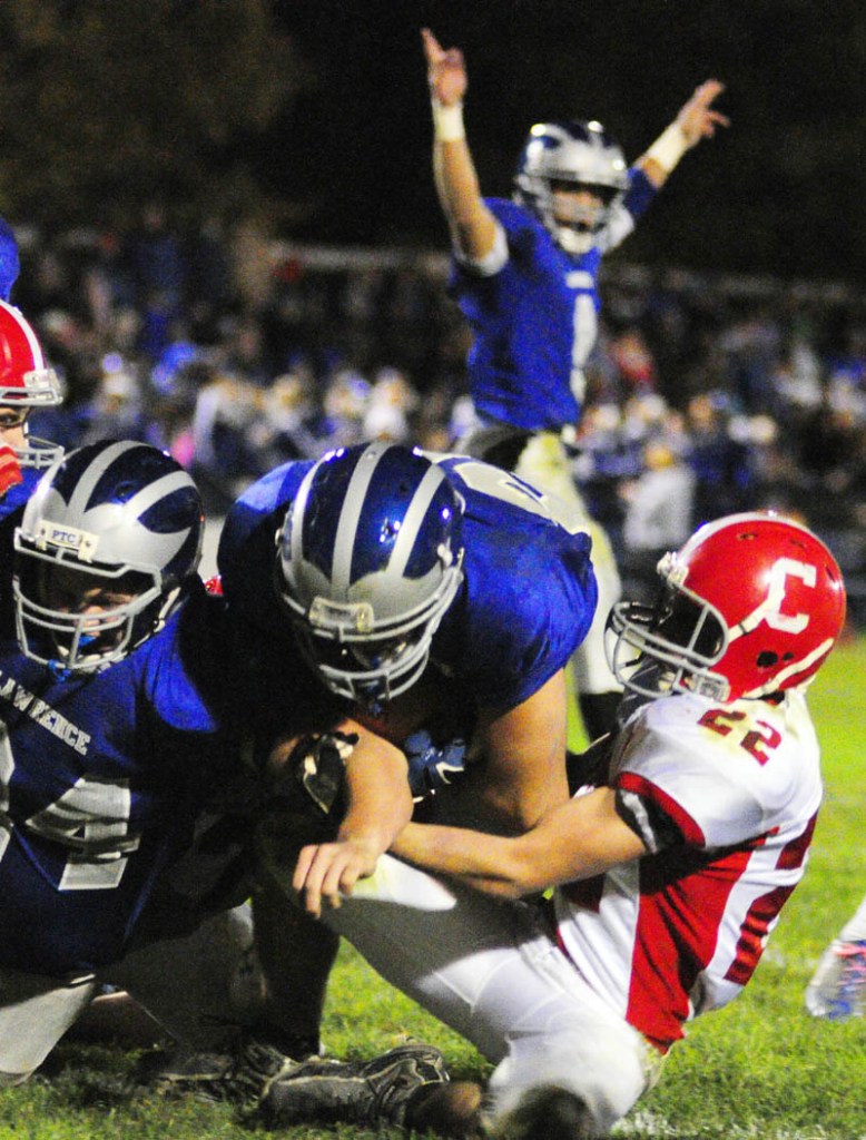 Lawrence's Jacob Gerow, left, blocks as Anthony Sementelli crosses the goal line with Cony's John Bennett, right, tries to stop him during a game on Friday night at Lawrence in Fairfield. Lawrence quarterback Spencer Carey, top, celebrates the Bulldog's third touchdown of first half.