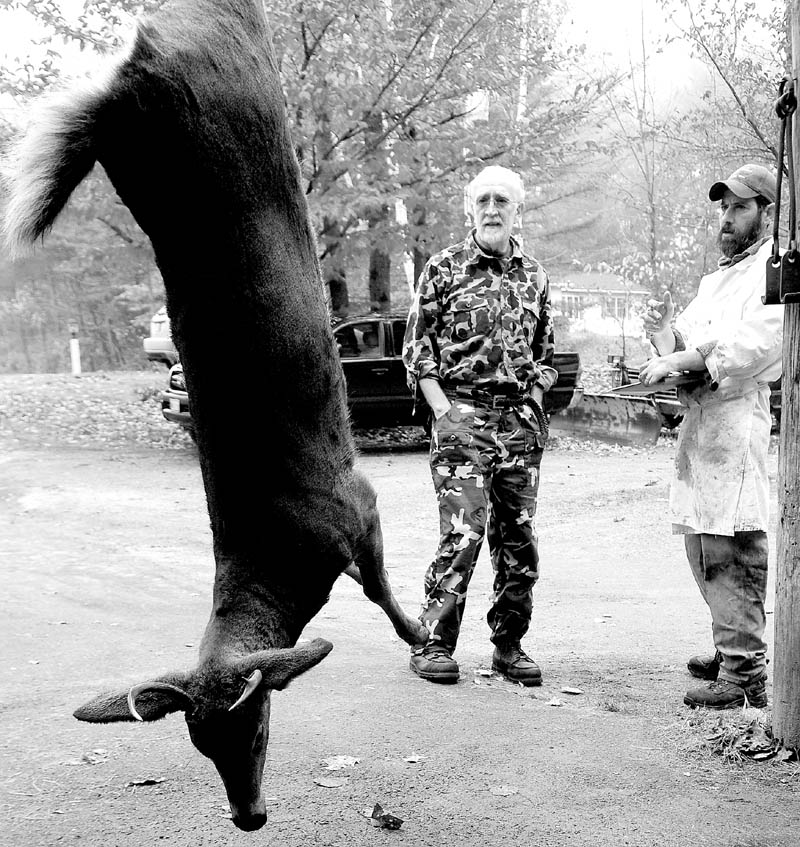 Hunter Nat Crosby, of Wayne, left, and meat cutter Brandon Fike discuss how he'd like his deer meat processed on Saturday at Ballard Meats and Seafood in Manchester.