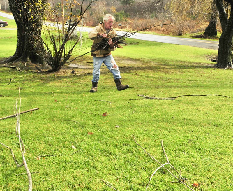 Alfred Jones picks up sticks blown down by Superstorm Sandy on Tuesday afternoon in the yard of his Vassalboro home. "Wasn't really that bad, could be worse," said Jones. Jones said that he was trying to keep the yard cleaned up and looking good since he is trying to sell the place.