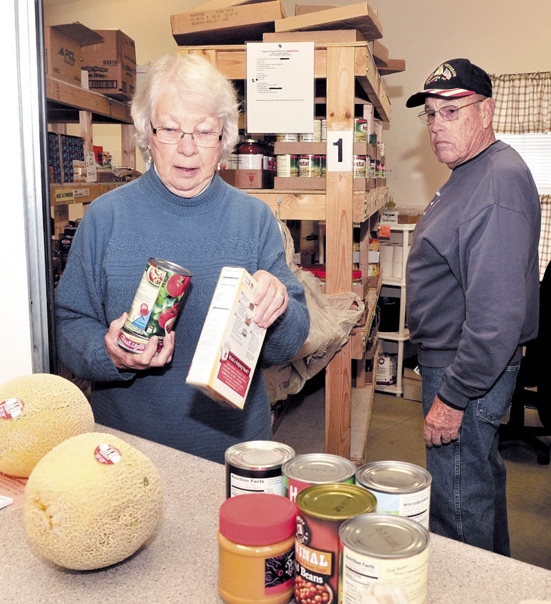 Volunteer Betty Lou Jones fills a request at the Greater Waterville Area Food Pantry in Waterville on Wednesday. Jones is leaving the organization after serving since it was started. At right is volunteer Ken Libby.