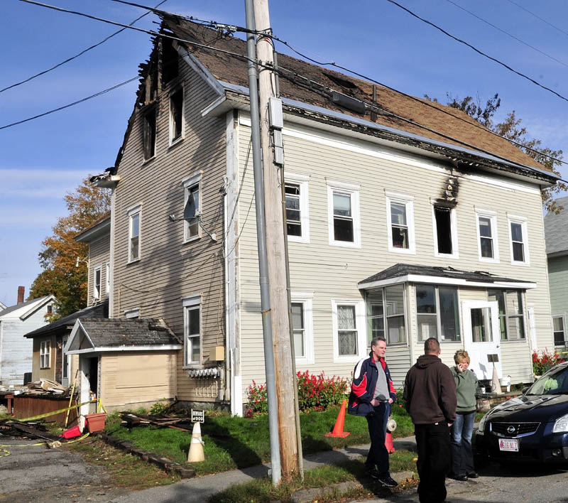 Tenants of this Pittsfield apartment building gather outside as an insurance adjuster takes notes inside on Sunday. Fire destroyed the building early Saturday morning. From left are David Halpin, Fred Spaulding and Danielle Aiken.