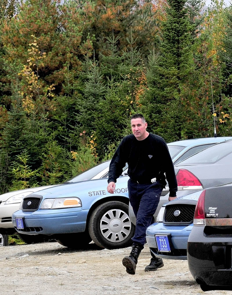 State police Sgt. Troy Gardner exits a Major Crimes Unit command post in the woods off the Rowe Pond Road in Pleasant Ridge as investigators combed the nearby woods.