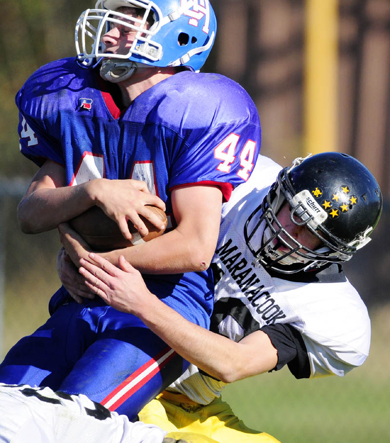 Oak Hill running back Kyle Flaherty, left, gets taken down by Maranacook defensive back Cody Lyon during a game on Saturday afternoon at Oak Hill High School in Wales.