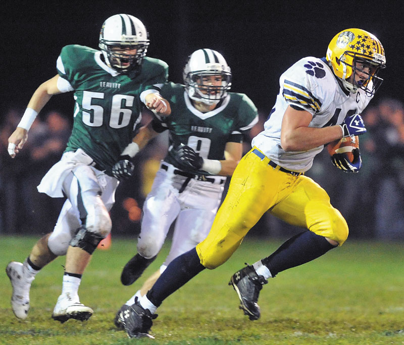OFF AND RUNNING: Mt. Blue High School running back Chad Luker, right, breaks away from Leavitt defenders for a long touchdown run early in the first quarter Friday at Leavitt Area High School in Turner.