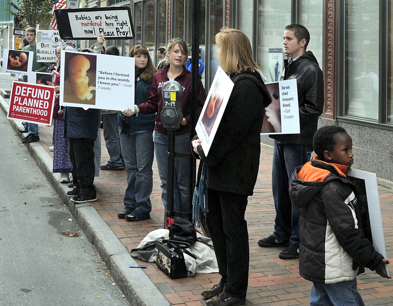 Anti-abortion demonstrators protest with graphic signs outside the Planned Parenthood of New England agency on Congress Street in Portland.