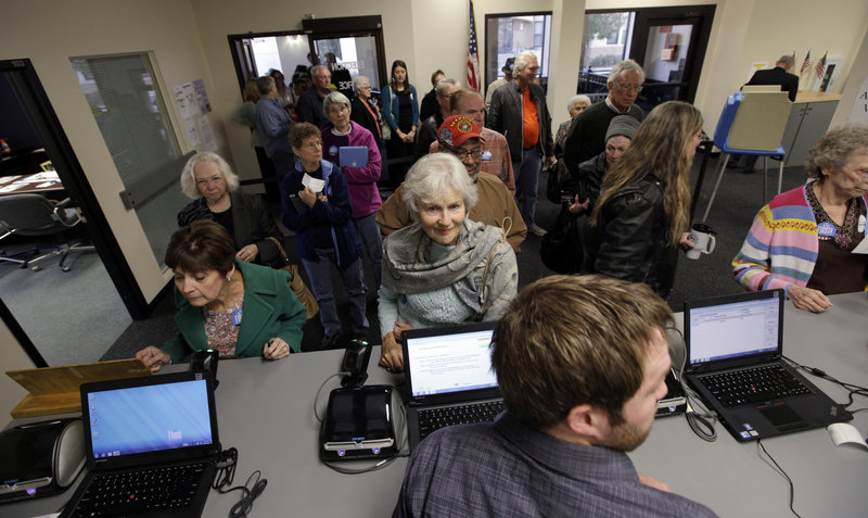 Voters wait for their ballots on Sept. 27, the first day of early voting for the November presidential election in Des Moines, Iowa. About 35 percent of voters nationwide are expected to cast their ballots before Election Day, Nov. 6, either in person or by mail.