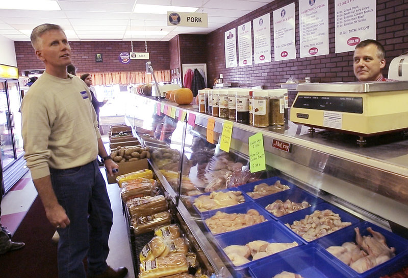 Charlie Summers checks the menu at Hoggy’s after Mark Hoglund, owner of the deli/sandwich shop, told him about one of the deli’s specialty sandwiches on Saturday. Summers was campaigning in Windham and had stopped in at a few businesses along Route 302.